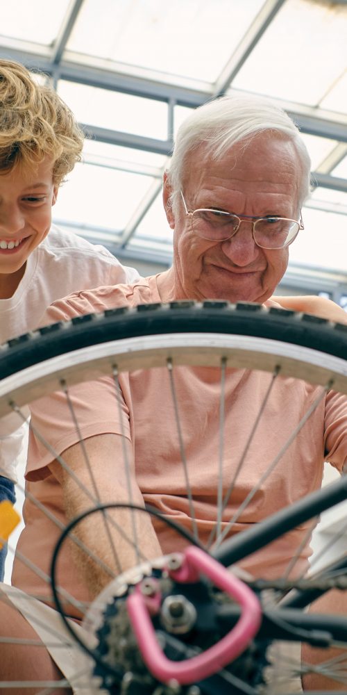 smiling old man fixing bicycle with grandson 2022 01 18 23 41 55 utc min
