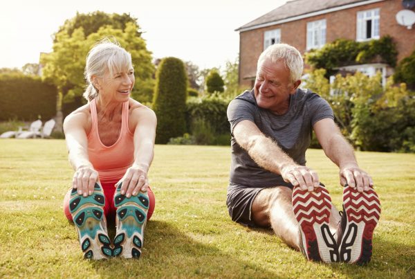 healthy senior couple exercising in garden togethe PXAP73D min