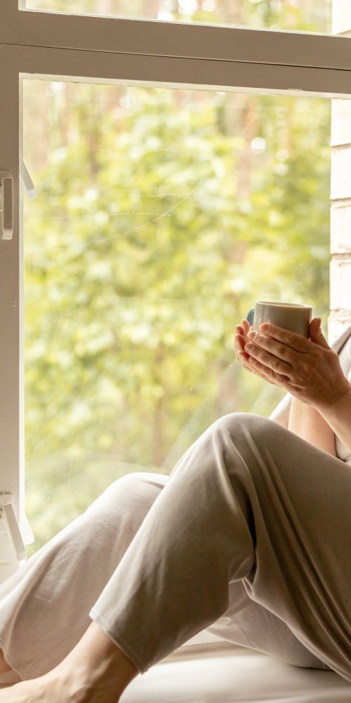 middle age beautiful woman sitting on windowsill 2022 11 16 12 24 13 utc