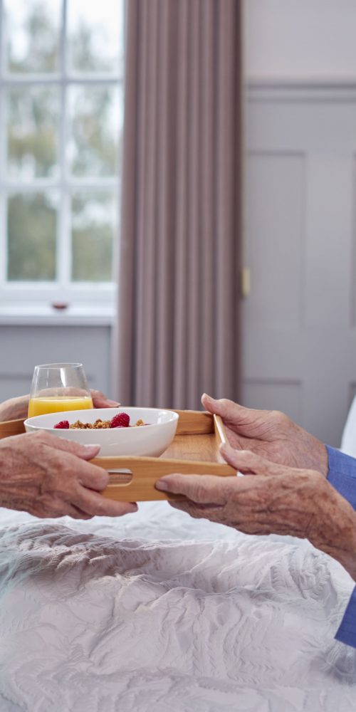 senior couple at home with woman bringing senior m 2022 04 04 21 34 37 utc min