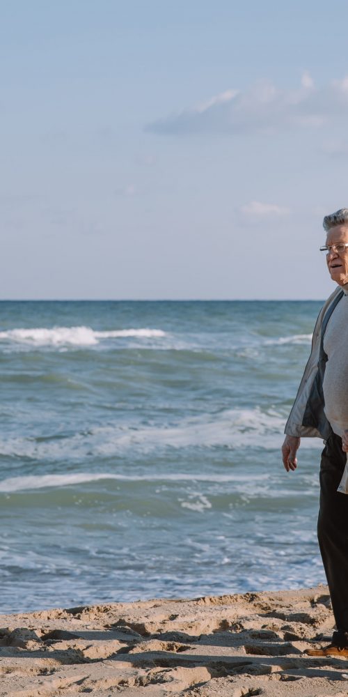 senior couple hugging and walking on seashore 2022 04 29 06 10 40 utc min