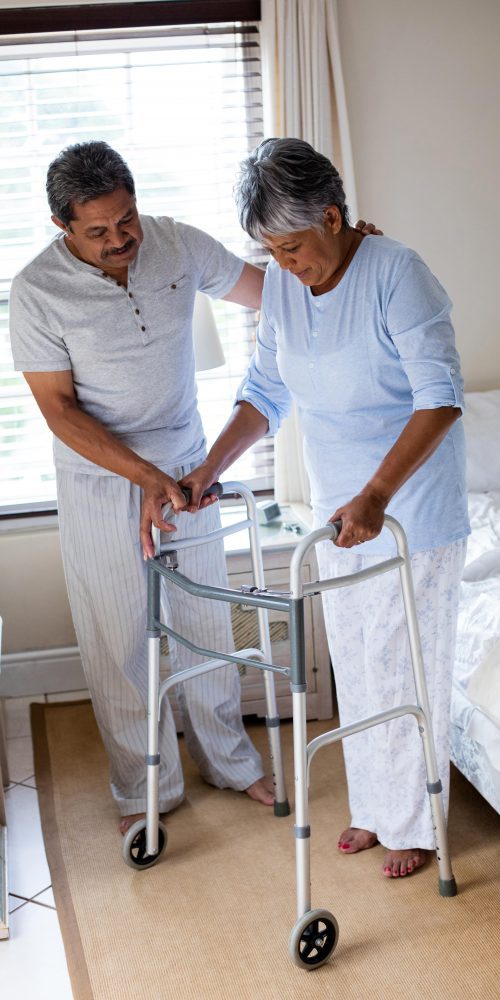 senior man helping senior woman to walk with walke 2021 08 28 16 45 13 utc min