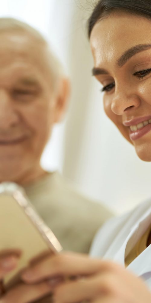 smiling nurse and senior citizen looking at smartp 2021 12 09 07 35 45 utc min
